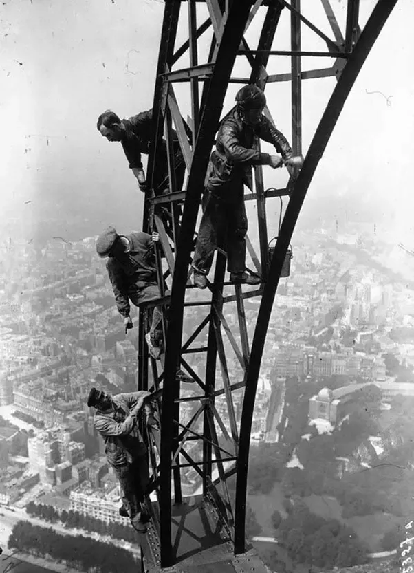 Fotografía de obreros pintando la Torre Eiffel
